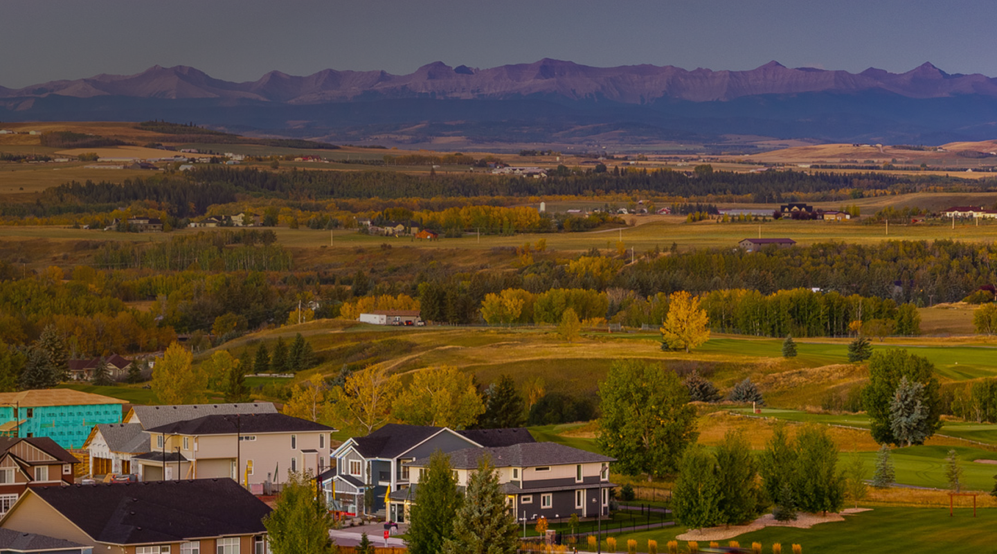 Aerial view of D'ARCY community in Okotoks with new homes and Rocky Mountains in the background